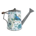 Photo d'un arrosoir vintage blanc et bleu émaillé avec fleur et oiseau finement dessinés une anse carrée à l'arrière et une en bois à rabattre le tout sur fond blanc