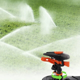 Arroseur de jardin noir et orange posé sur une pelouse.