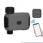 Programmateur d'arrosage automatique sur fond blanc avec un téléphone à côté.