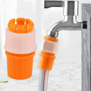 Photo d'un embout orange et blanc de tuyau raccordé à un robinet argenté d'un côté et à un tuyau gris à rayure orange de l'autre sur un fond bleu-gris