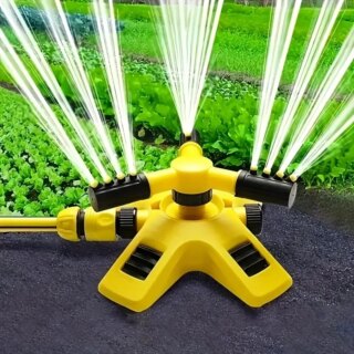 Arroseur de jardin rotatif jaune posé près d'une pelouse.