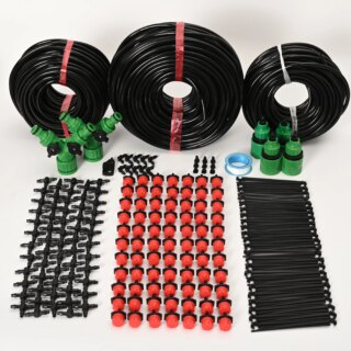 Photo montrant trois rouleaux de tuyaux noirs posés sur le tranche et devant eux les accessoires des kits d'arrosage en grande quantité bien rangés en 3 bandes une rouge au milieu des noires et les connecteurs verts entre les tuyaux et les accessoires le tout sur un fond blanc