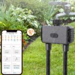 Programmateur d'arrosage automatique à 2 sorties branché sur un robinet et avec un téléphone à côté.