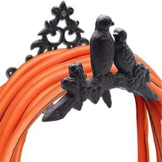 Support de tuyau marron avec 2 oiseaux en décoration. Un tuyau d'arrosage orange y est enroulé