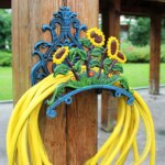 Support mural de tuyau d'arrosage avec des fleurs de tournesol et un tuyau jaune