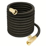 Sur fond blanc, on voit un tuyau d'arrosage extensible noir avec des embouts en laiton doré.