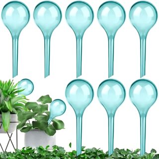 Kit d'arrosage goutte à goutte avec 10 pièces de couleur vert transparent en forme d'ampoules avec un tube sur la partie basse. A gauche, deux plantes dans lesquelles sont piquées deux pièces. Sur fond blanc.