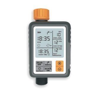 Programmateur d'arrosage automatique avec écran LCD. Le boitier est gris et orange. Les boutons sont gris clair et orange sur la partie basse du boitier. De forme rectangulaire avec une sortie au-dessus et une sortie en dessous. Sur fond blanc.